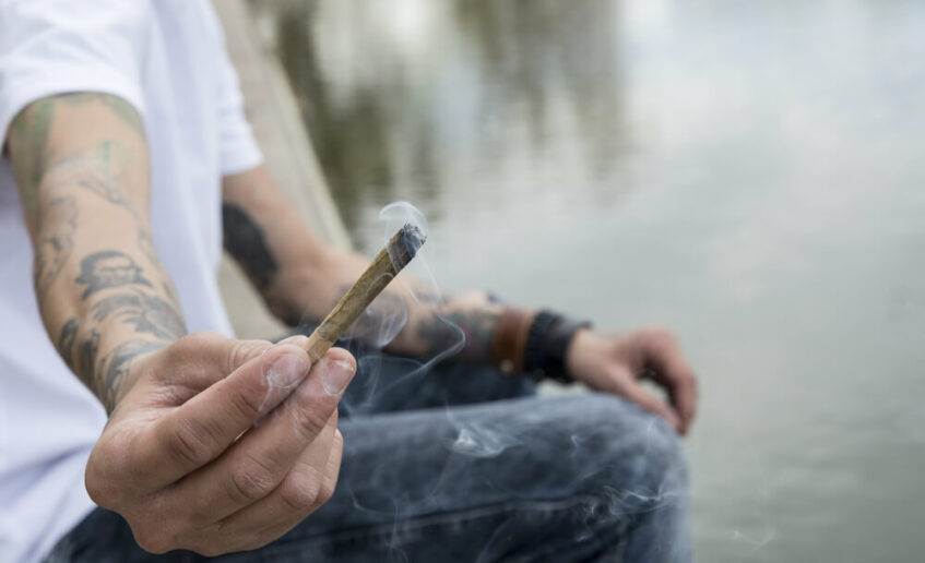 A young man passes on a joint